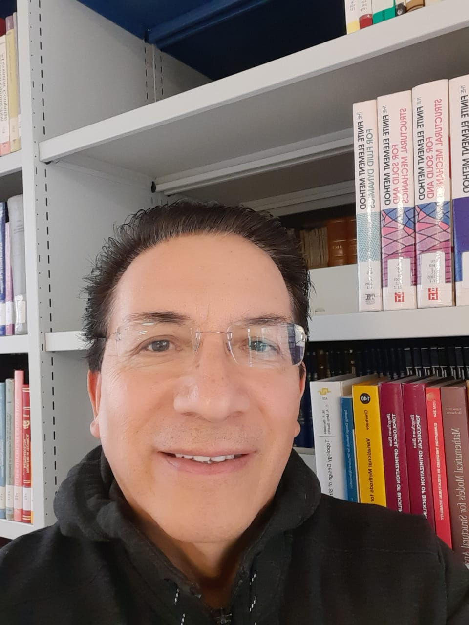 foto de Felipe Meneses com uma biblioteca de fundo