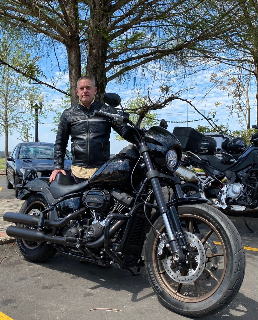 foto dele ao lado de sua Harley-Davidson