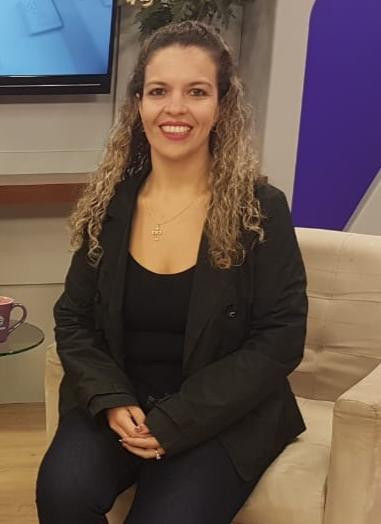 foto da fonoaudióloga Tatiane Vieira sentada em uma poltrona marrom claro