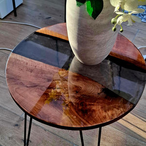 Table d'appoint en noyer massif et résine noire transparente métallisée.