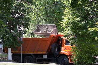 excavator-bucket-putting-construction-garbage-into-tipper-body-summer-park.jpg