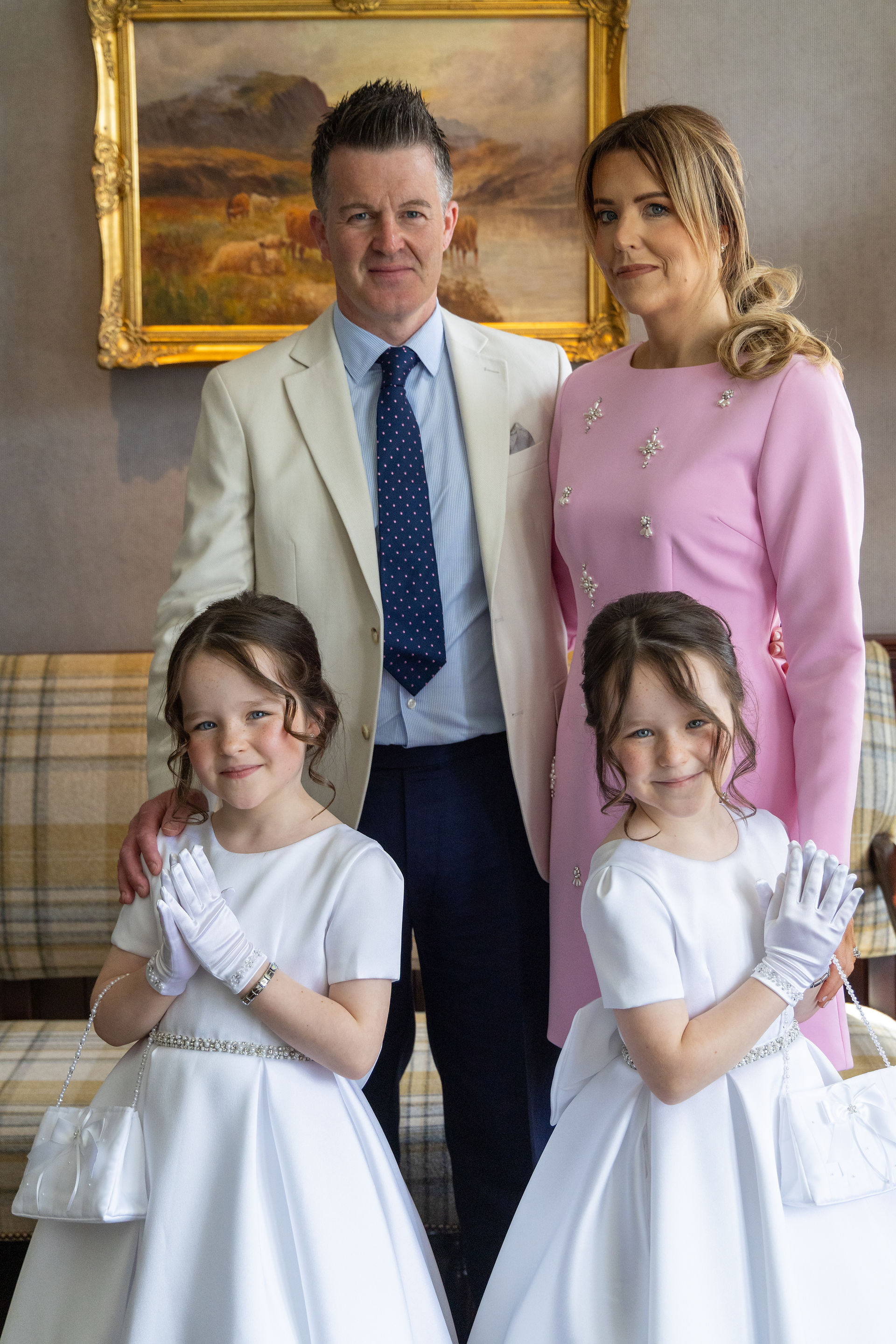 Family portrait with two girls in white communion dresses