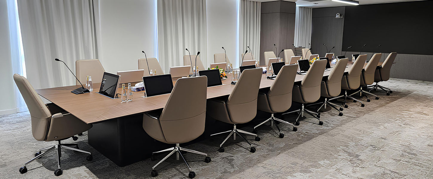 A real custom-made rectangular boardroom table with integrated monitors, manufactured by TURADI in Italy, for a governmental entity in Saudi Arabia.