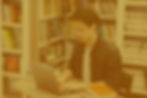 A guy using a computer in a library