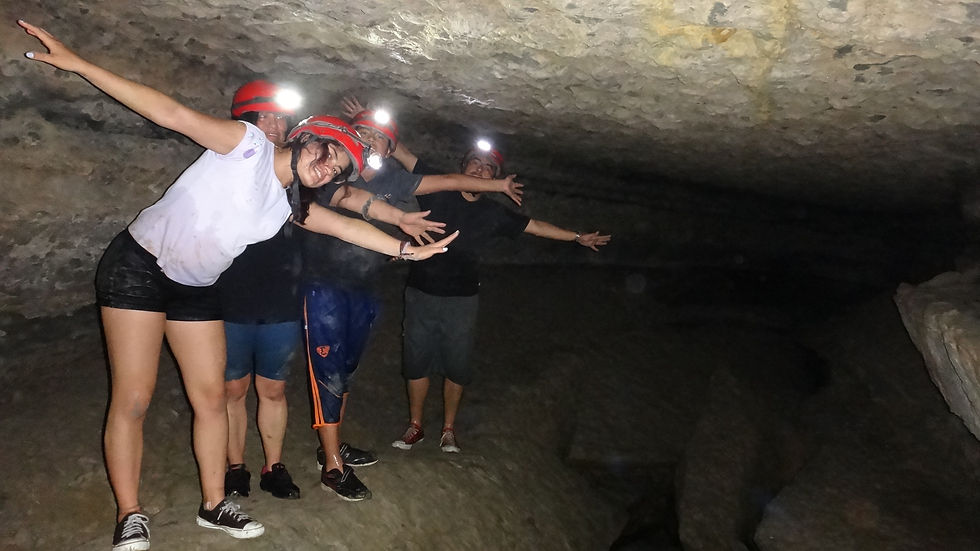 Familia feliz explorando la Caverna "Lagarto" en Archidona Napo, con los brazos abiertos y listos para abrazar la emoción y la aventura de descubrir las maravillas subterráneas