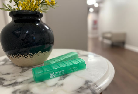 Close-up of Parkview Assisted Living’s daily pill organizers on a marble table beside a decorative vase, symbolizing careful medication management and attention to detail.