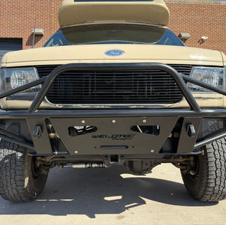 Close-up of aftermarket steel front bumper and grille guard on Ford camper van