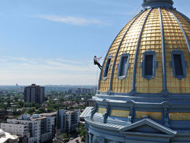 High-altitude painter descending the historic Colorado Capitol Dome using rope access for precision coating and preservation work.
