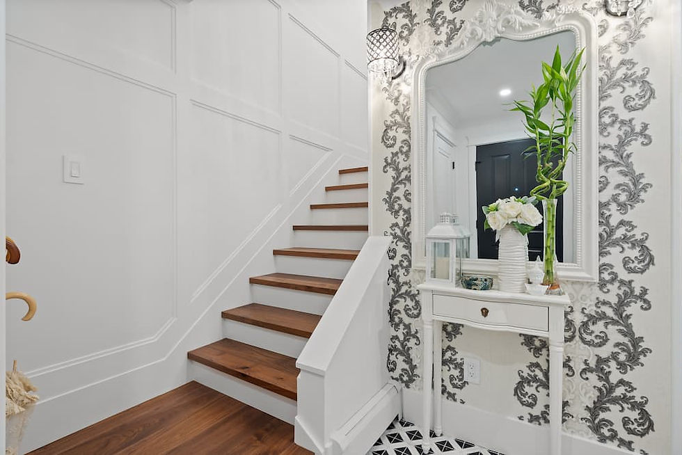 A staircase with wainscotting and decorative wallpaper