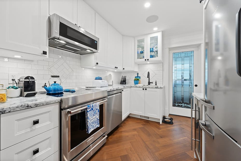 A white, renovated kitchen with herringbone floor