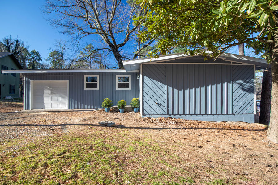Newly remodeled flip house front exterior features freshly painted blue siding and white trim.