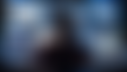 Pessoa cercada por múltiplas telas digitais em ambiente escuro, representando sobrecarga tecnológica