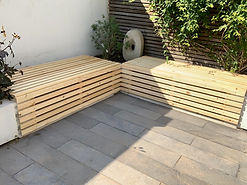 Redwood exterior benches, made with slats. They open and close with a waterproof storage area inside of the bench.