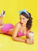 Modèle pin-up en maillot de bain rose posant sur fond jaune, inspiration pour le workshop photo vintage près de Lille.