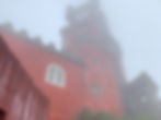 A red tower shrouded in clouds at Palacio de Pena in Sintra, Portugal