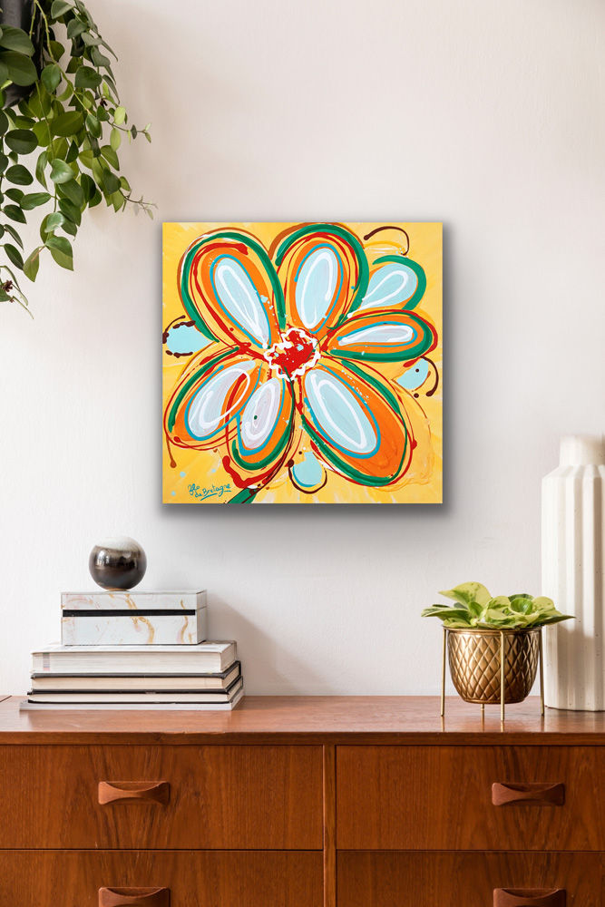 Thumbnail: the painting of a yellow flower is hanging above a wooden table with a pile of books and an indoor plant