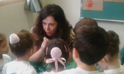 Foto da autora Shirley Souza conversando com um grupo de crianças.