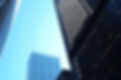 Two Toronto buildings are climbing up on a diagonal towards the right corner, with a light blue sky in the background.