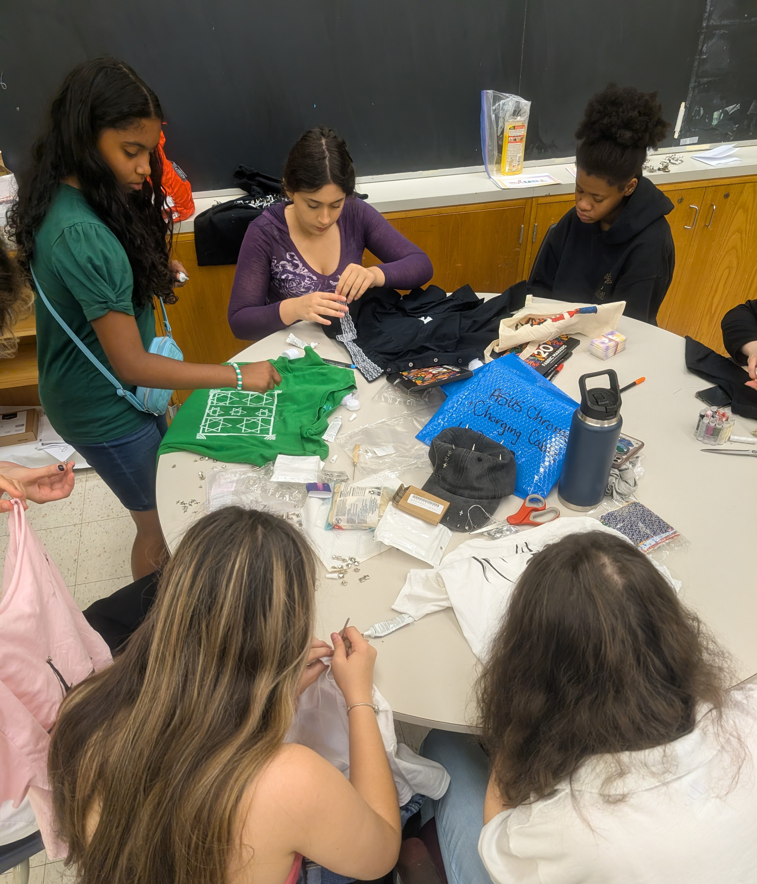 Participants creatively transform clothing through upcycled fashion projects, collaborating and sharing ideas at a workshop.