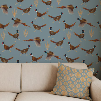 Comfortable sofa with a leaf patterned pillow and pheasant wallpaper behind the sofa