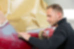 man wetsanding a rear bumper of a car