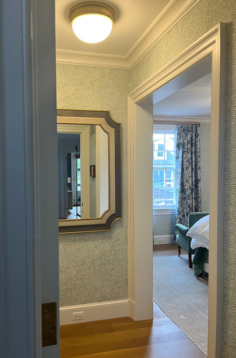 Bedroom entryway with wallpaper and mirror