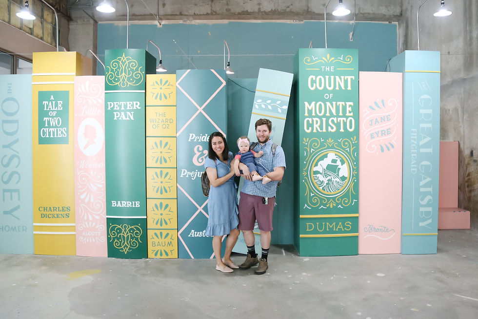Multicultural family in front of book spine sculpture at an interactive museum