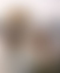 An elderly Sikh man wearing a white turban and kurta stands waist-deep in the sacred pool of the Golden Temple, gently cupping water in his hands and bringing it to his face in a quiet act of devotion. Behind him, another Sikh man in white stands in the water with hands folded in prayer, facing the temple. Soft morning light reflects off the calm water and the golden sanctum, creating a serene, reverent atmosphere rooted in Sikh spiritual practice.