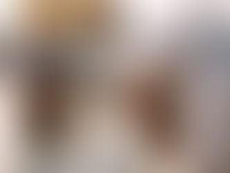 An elderly Sikh man wearing a white turban and kurta stands waist-deep in the sacred pool of the Golden Temple, gently cupping water in his hands and bringing it to his face in a quiet act of devotion. Behind him, another Sikh man in white stands in the water with hands folded in prayer, facing the temple. Soft morning light reflects off the calm water and the golden sanctum, creating a serene, reverent atmosphere rooted in Sikh spiritual practice.