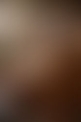 Alt text: An elderly Sikh man in a saffron turban and earth-toned robe sits beneath a broad, ancient tree, reading from an open sacred scripture resting on a carved wooden stand. Soft morning sunlight filters through the leaves, illuminating the pages, while a distant stone temple and forested hills blur gently in the background, creating a quiet, contemplative atmosphere of study and reverence.