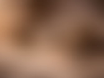 Still-life scene with an ancient book and rolled parchment resting on stacked wooden boards, a smooth stone, a small steaming bowl, a wooden brush, and dried herbs arranged on soft linen in warm, earthy light.