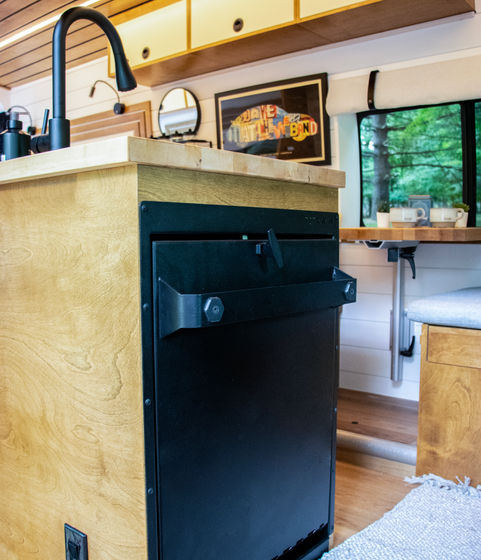 Tetra shower fully stowed inside a camper van, with the unit folded down and curtain stored, showcasing its compact design for maximizing interior space.