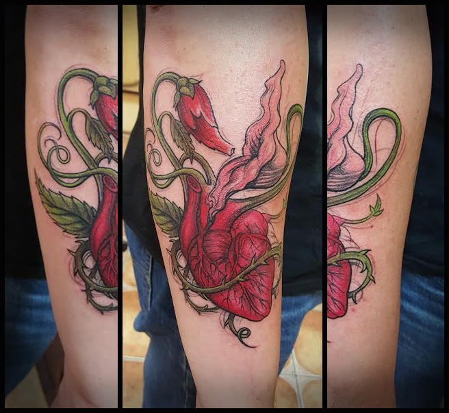 A vibrant red heart tattoo entwined with chili peppers and green vines, showcasing a unique fusion of organic elements and anatomical features, ideal for those seeking artistic and symbolic body art.