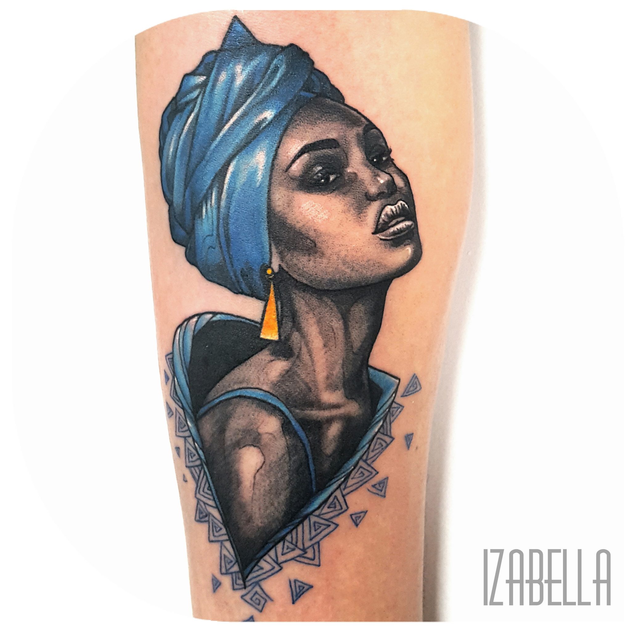 A vibrant tattoo featuring a woman with a blue turban and golden earrings, depicted in a realistic style. The design includes geometric patterns around her silhouette, creating a striking visual effect. The woman's expression is confident and captivating, highlighting her strong features and elegance.