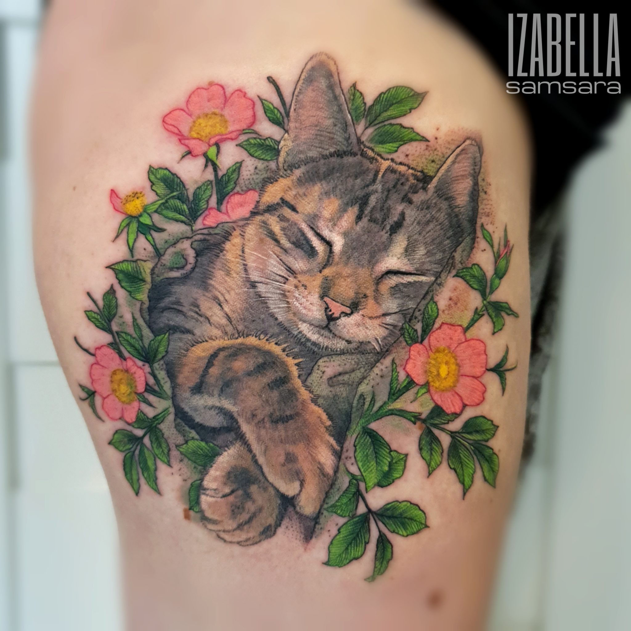 A vibrant tattoo featuring a sleeping tabby cat surrounded by pink flowers and green leaves, showcasing realistic details and a colorful design, perfect for cat lovers and nature enthusiasts.