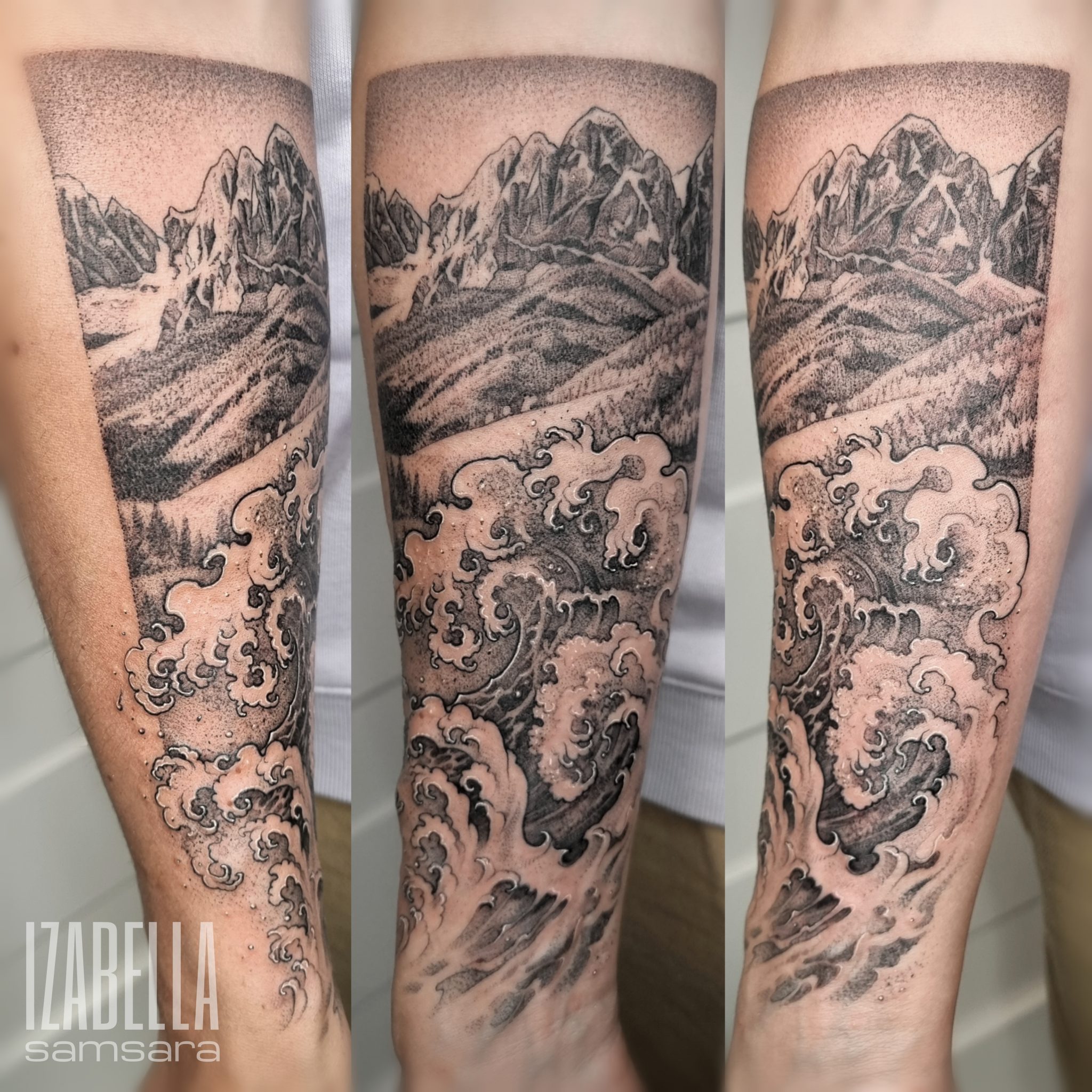 A black and grey tattoo covering the forearm, featuring a dramatic mountain landscape with detailed peaks and valleys, descending into swirling ocean waves below. The mountains are shaded with pointillism techniques, creating depth, while the waves display intricate line work and shading, giving a sense of movement and fluidity.