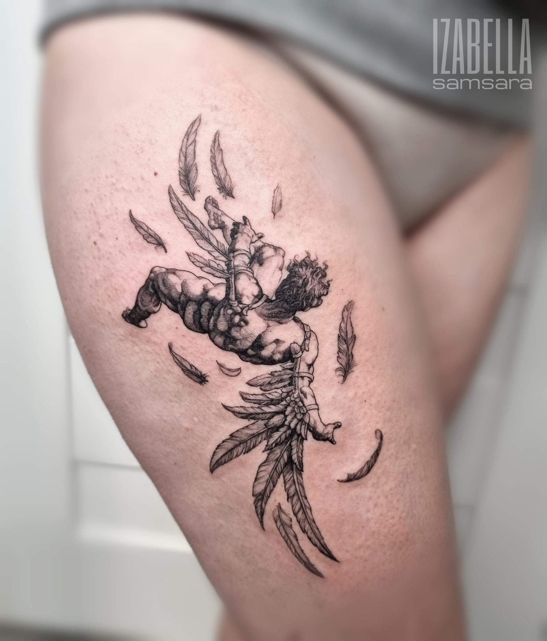 A detailed black and white tattoo depicting a muscular figure with flowing hair and angelic wings, soaring among fluttering feathers. The figure appears to be in motion, possibly expressing freedom or struggle, with intricate details highlighting the anatomy and wing structure.