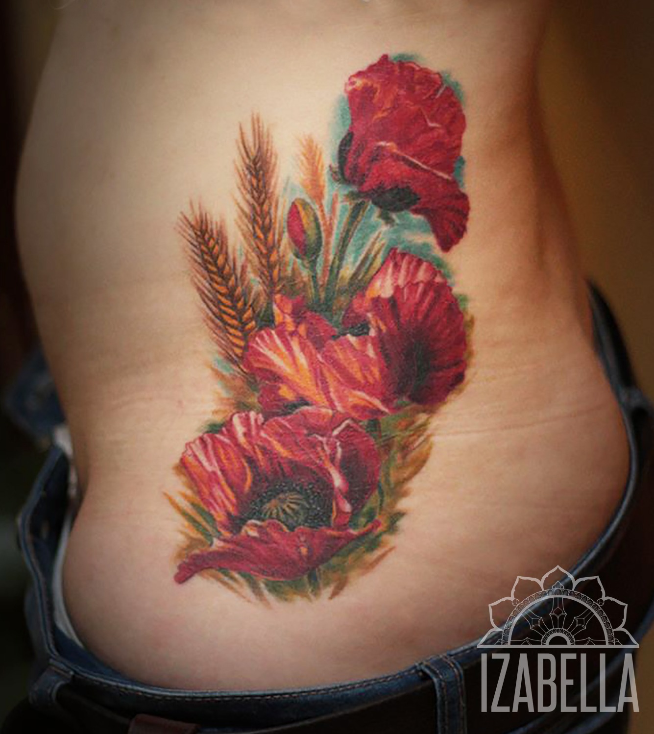 A vibrant and colorful tattoo featuring blooming red and orange poppies, interspersed with green leaves and golden wheat stalks. The floral design is artistically arranged and emphasizes the natural beauty of the flowers, showcasing intricate details and vivid colors on the side of the torso.