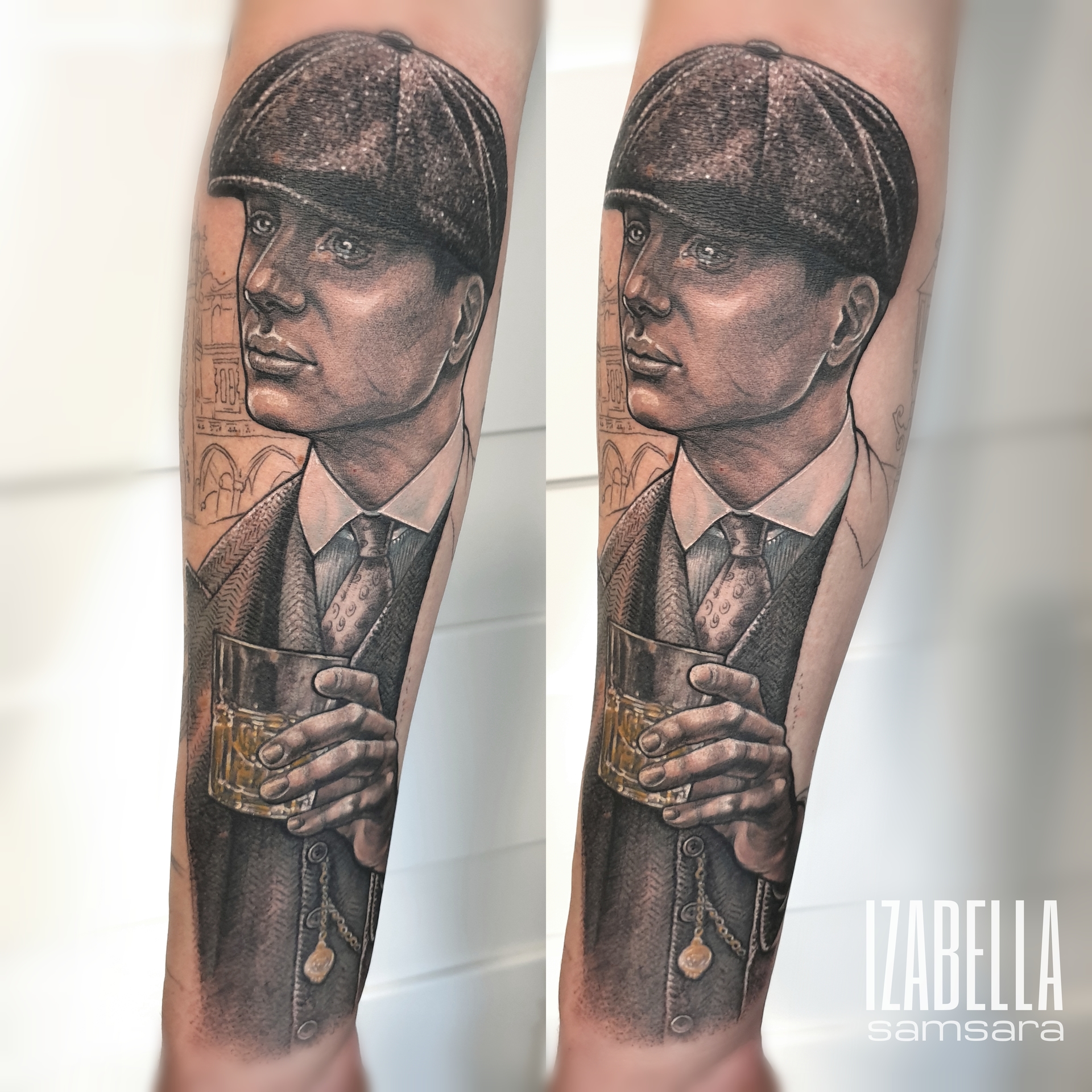 A detailed black and gray tattoo depicting a man in a vintage outfit, wearing a flat cap. He is holding a glass of whiskey and has a chain in his pocket, with intricate shading highlighting his facial features and attire. The background features faint architectural elements, adding depth to the design.