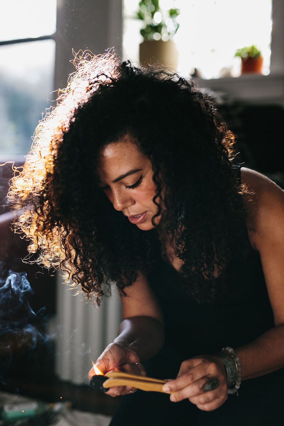 Mara burning palo santo at Serenità Retreats in Sardinia, Italy, during a holistic healing and energy cleansing ceremony