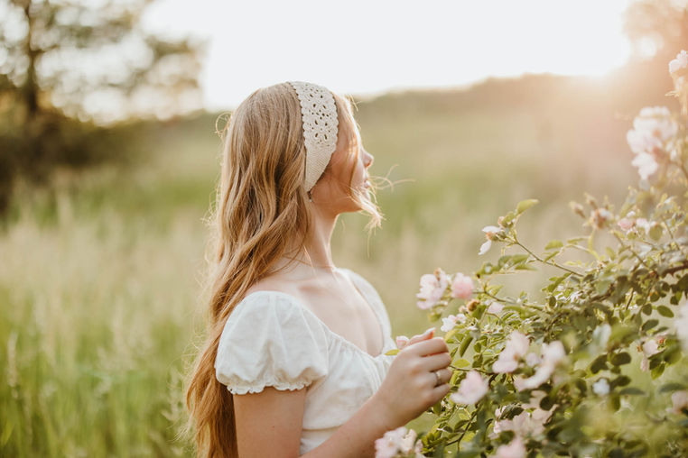 senior girl turned away towards the sunset holding a pink rose in Liberty Lake, Washington