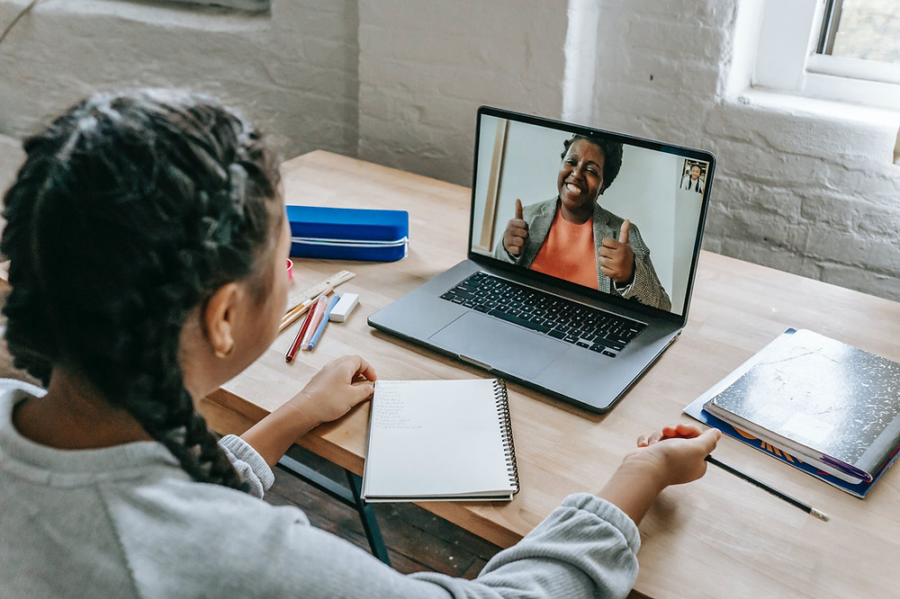 Student engages in video chat with instructor on laptop computer