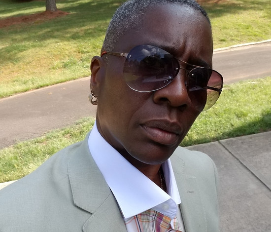 Picture of Jae wearing a tan suit and sun glasses