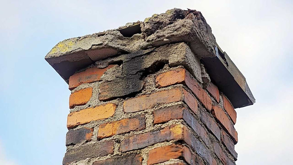Damaged brick chimney with cracked mortar against a cloudy sky background, showing weathered and blackened edges.