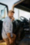 Happy truck driver entering in vehicle cabin and looking at camera.                       