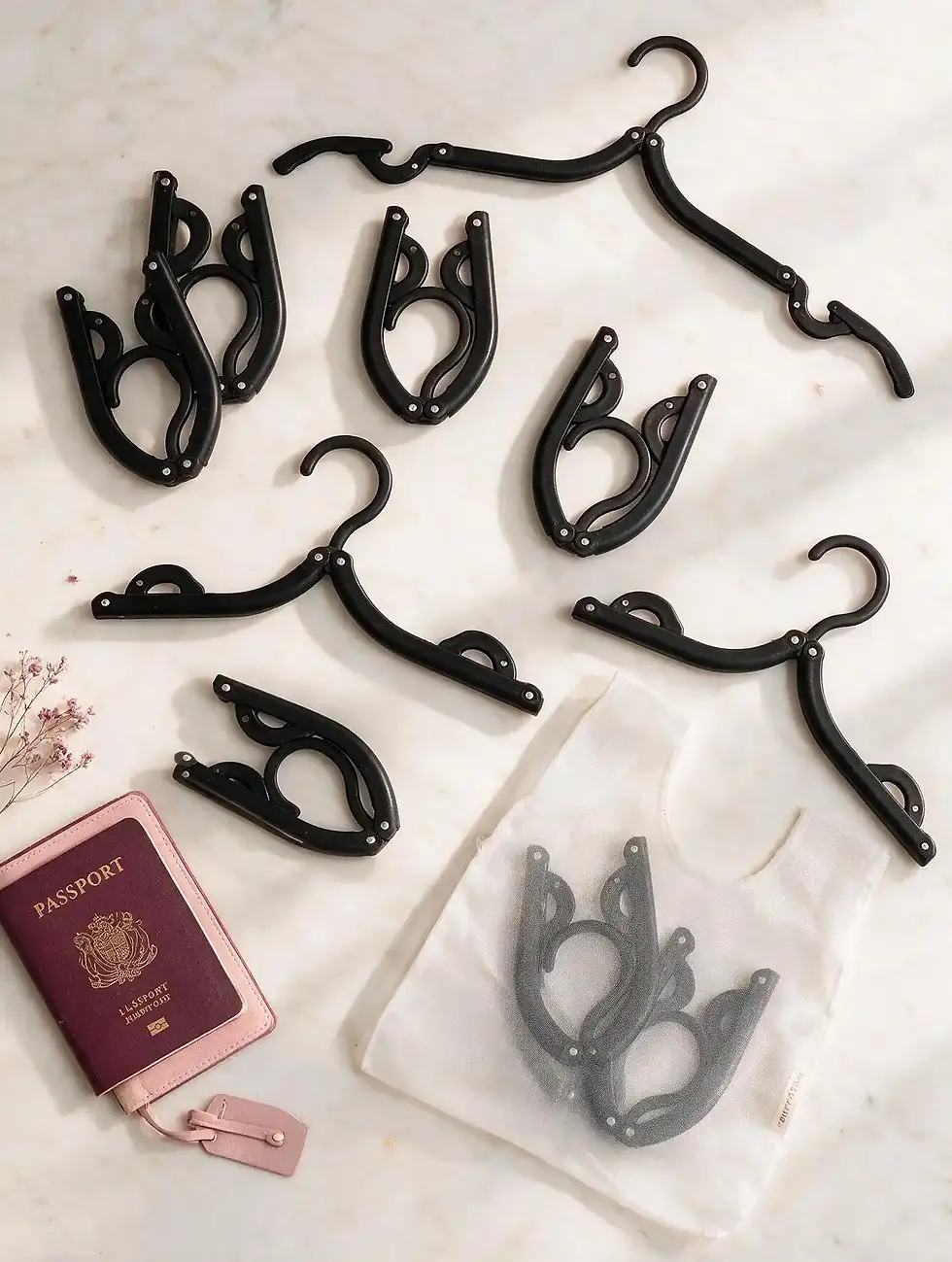 Thumbnail: Flat lay of black travel hangers with a passport and carrying pouch, ready for travel.