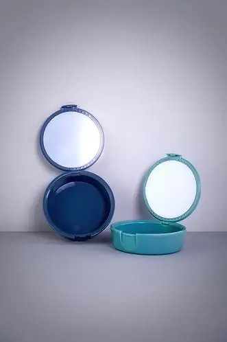 Pair of aligner case holders with built-in mirrors displayed on a clean surface.