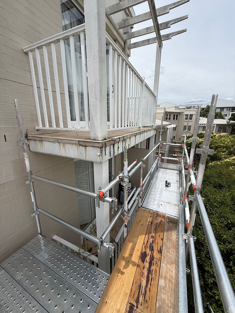 Apartment scaffolding wrapped along façade at Breakfast Point