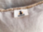 makers tag attached to the back of a pillow. Tag has a black dog and 2 yellow cats