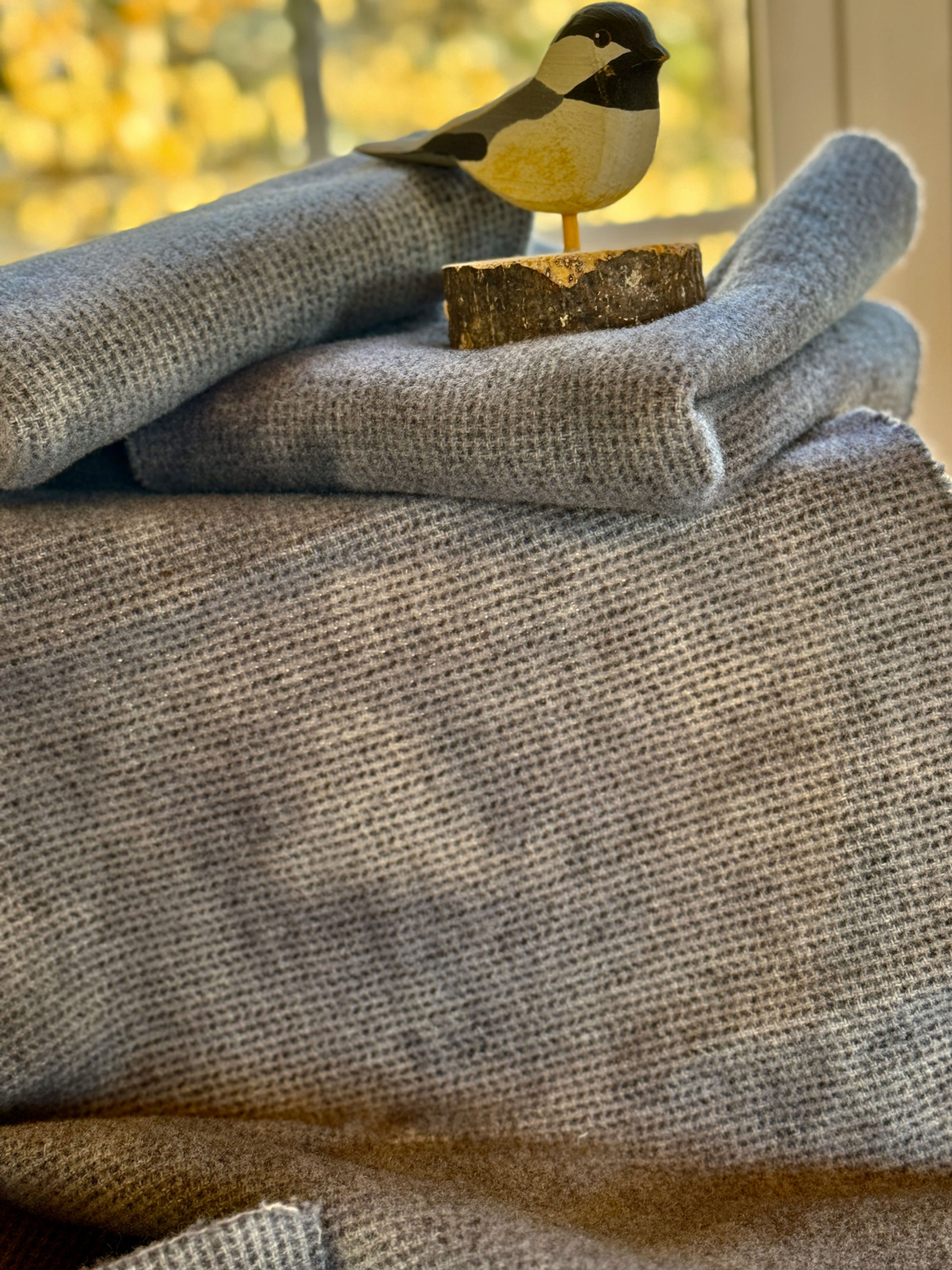 Ash gray hand dyed wool fat quarters with a bit of a wooden chickadee showing on the top.